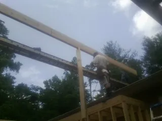 Carpenter setting a ridge beam over a new addition frame — Ice Dam Removal by Roofing Brothers in East Lynn