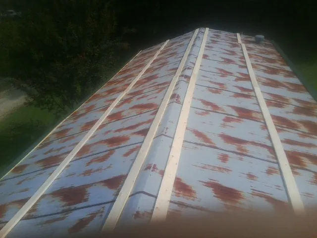 Rusted metal roof panels with new wood purlins before replacement — Storm Damage Roof Repair in East Lynn by Roofing Brothers