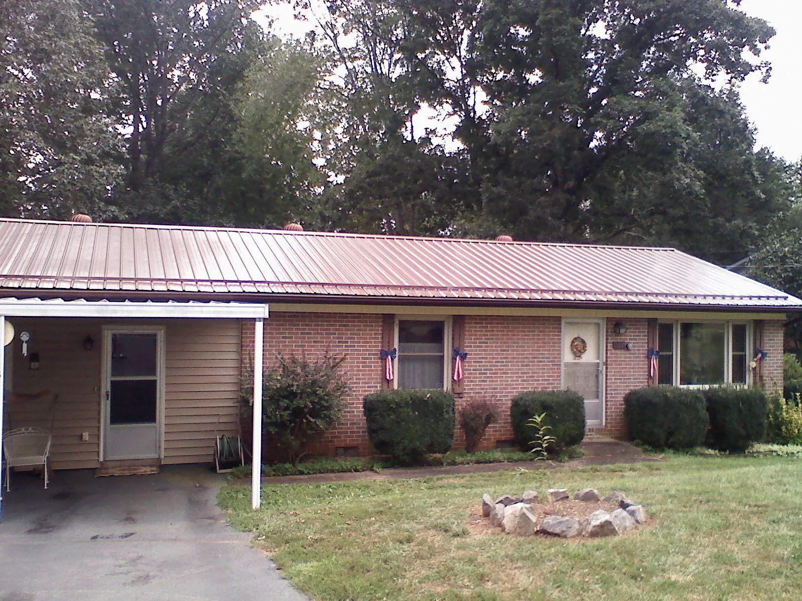 Bronze metal roof and carport on a brick ranch home — Roof Repair work by our crew in East Lynn